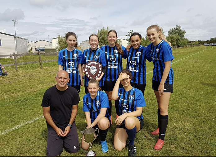 TFC U18s Girls with the Adam Bowey Shield and coach Dean Gonsalves with the Manager of the Season trophy